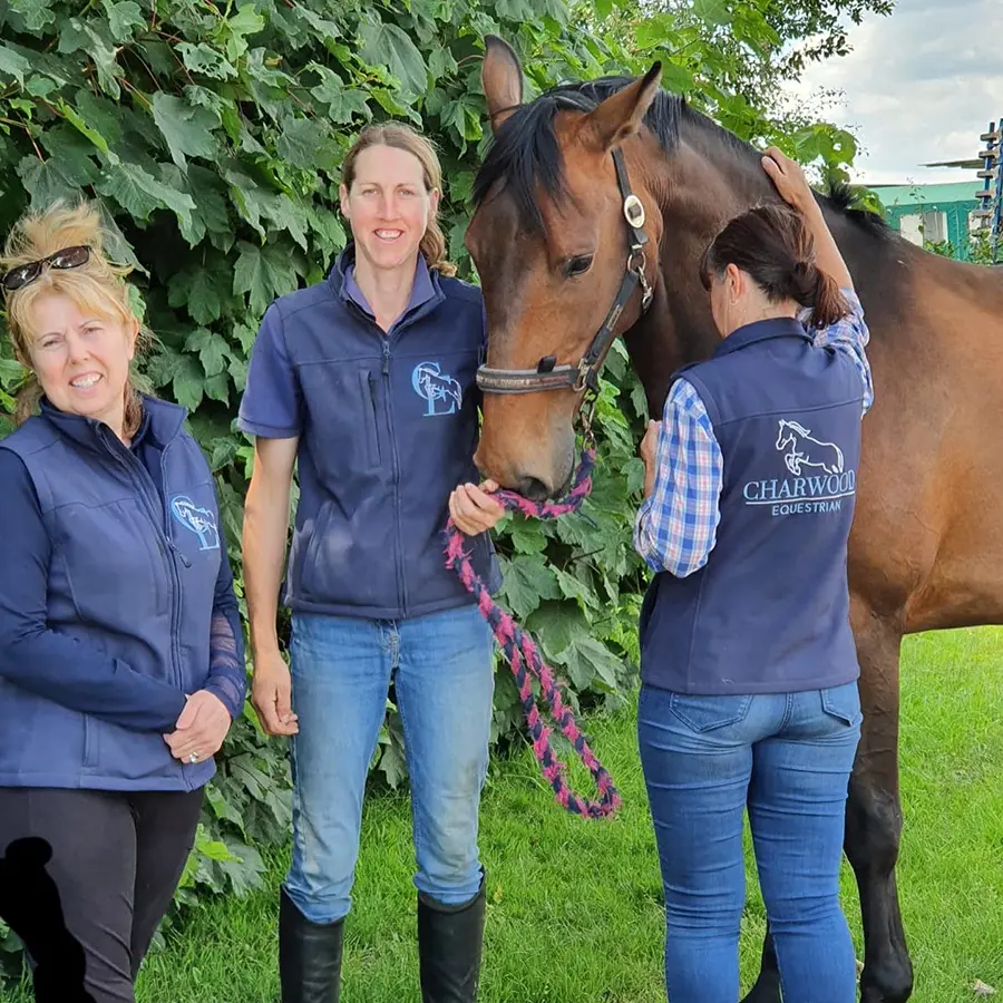 Horse and women standing with embroidered workwear